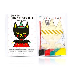 May include: A black cat witch sand art DIY kit. The kit includes a pre-cut wooden board, coloured sand, a toothpick, and a twist tie. The kit is packaged in a clear plastic bag with a colourful design.