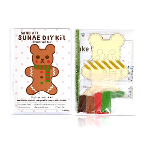 May include: A Sand Art SUNAE DIY Kit with a gingerbread bear design. The kit contains coloured sand, a pre-cut board, instructions, a toothpick, and a twist tie. The challenge level is two out of three stars.
