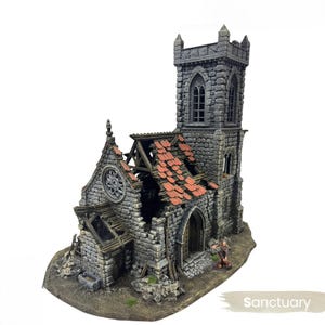 Könnte beinhalten: Eine Miniaturkirche aus verwittertem Stein mit einem hohen Turm und einem teilweise eingestürzten Dach. Die Dachziegel sind rot und die Wände grau. Die Kirche hat Bogenfenster und ein kreisförmiges Fenster. Das Wort "Sanctuary" ist auf der Basis aufgedruckt.