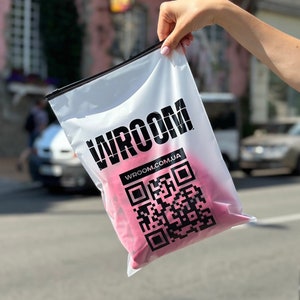 May include: A clear plastic bag with a pink item inside. The bag has the word "WROOM" printed in black letters and the website "WROOM.COM.UA" printed below. A black and white QR code is also printed on the bag.