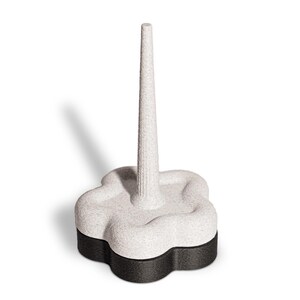 Può includere: Un portaanelli decorativo con un lungo palo strutturato bianco sporco che si erge da una base a forma di fiore. La base è bicolore, con una parte superiore maculata bianco sporco e una parte inferiore nera. Il portaanelli è progettato per esporre anelli.