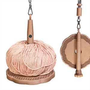 Può includere: Un set di rocchetto e avvolgitore per filati. Il rocchetto è marrone, dal design circolare decorativo con una catena. L'avvolgitore è marrone e contiene una palla di filato color pesca. Il set è progettato per lavorare a maglia e all'uncinetto.