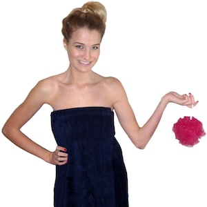 May include: A navy blue, strapless, terry cloth wrap with the name "Sarah" embroidered on the front. The wrap is being held by a person who is also holding a pink bath pouf.