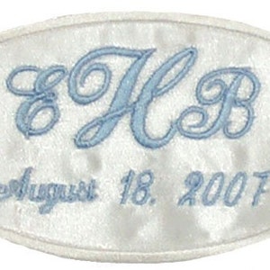 May include: White oval satin patch with blue embroidered initials "HB" and the date "August 18, 2007".