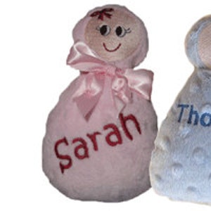 Puede incluir: Dos muñecas de peluche para bebés, una rosa con el nombre "Sarah" bordado y otra azul con el nombre "Thomas" bordado.
