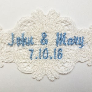 May include: White lace wedding patch with blue embroidery that reads "John & Mary 7.10.16".