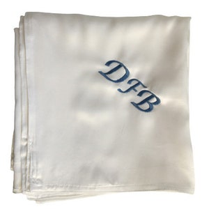 May include: White satin fabric with the initials "DFB" embroidered in blue.