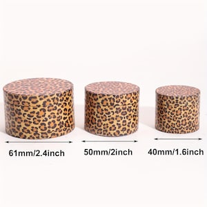Op de afbeelding: Drie ronde, meerlaags, opbergcontainers met luipaardprint. De containers zijn 61 mm, 50 mm en 40 mm in diameter.