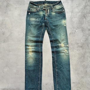 Könnte beinhalten: Verblasste blaue Jeans mit abgenutzten Details, einschließlich Rissen und Patches. Die Jeans haben ein klassisches Fünf-Taschen-Design und einen Knopf- und Reißverschluss. Der Denim hat einen abgenutzten, Vintage-Look.