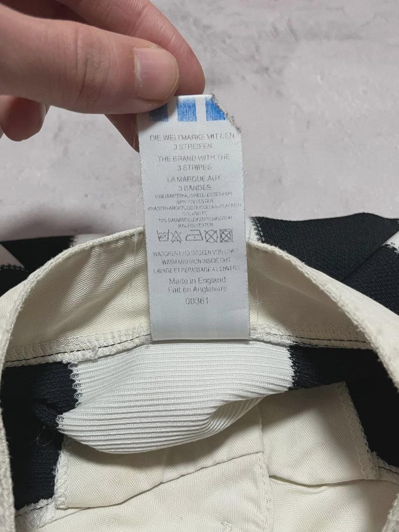 Puede incluir: Una taza de cer&aacute;mica blanca con un asa negra y el texto "But First, Coffee" en negro y negrita. La taza est&aacute; sobre una superficie de madera. La taza mide aproximadamente 10 cm de alto.
