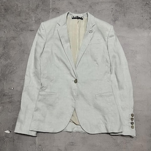 May include: A light blue blazer with a single-button closure, two front pockets, and three buttons on each sleeve. The blazer has a notched lapel and a small emblem on the chest. The interior lining is a light beige color.