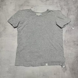 以下が含まれることがあります： クルーネックのヘザーグレーの半袖Tシャツ。シャツの裾近くに小さなタグがあり、首元にはラベルが付いています。生地は柔らかいニット素材のようです。