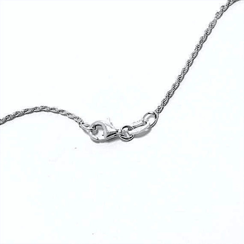 May include: Close-up of a silver necklace clasp and chain against a white backdrop. The chain has a twisted rope design. The clasp is a lobster claw style, and the metal appears to be polished.