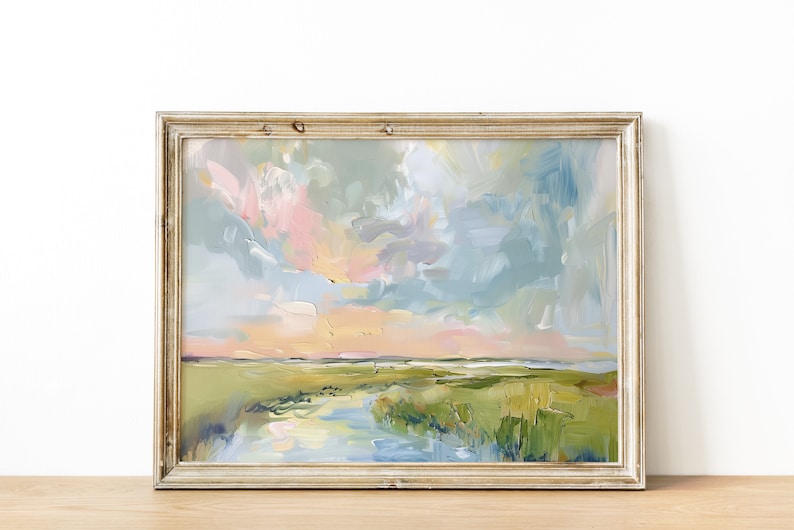 Op de afbeelding: Een abstract landschapsschilderij in een goudkleurige houten lijst. Het kunstwerk toont een levendige lucht met pastelroze, blauwe en gele tinten. De voorgrond toont een groen moeras met een waterpartij, wat een serene en kleurrijke sc&egrave;ne cre&euml;ert.