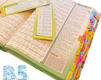 May include: Open Quran with colorful page tabs and bookmarks. The book is open to a page with Arabic script. The bookmarks have text in English and Arabic. The image also includes the text "B5 TAGS EDITION".
