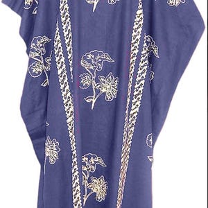 Op de afbeelding: Een lange, blauwe katoenen kaftan met een witte bloemenprint en een witte bies. De kaftan heeft een ronde hals en korte mouwen.