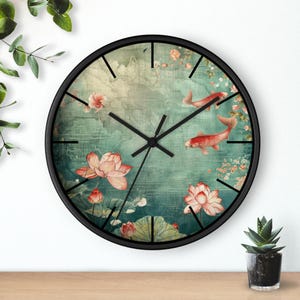 May include: Black round wall clock with a vintage-inspired design featuring red koi fish swimming in a pond with pink lotus flowers. The clock face has black Roman numeral hour markers and black hands.