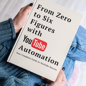 以下が含まれることがあります： 「From Zero to Six Figures with YouTube Automation」というタイトルの本が手に持たれています。表紙はオフホワイトで、黒い文字と赤いYouTubeのロゴが入っています。サブタイトルは「Your Complete Guide to YouTube Success」です。