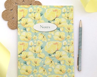Caderno de capa mole com estampa floral Buttercup e folhas quadriculadas.