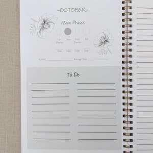 Pode incluir: Uma p&aacute;gina de planejador branca com o t&iacute;tulo "Outubro" e uma se&ccedil;&atilde;o para acompanhar as fases da lua. A p&aacute;gina inclui ilustra&ccedil;&otilde;es de flores e as diferentes fases da lua. H&aacute; tamb&eacute;m uma se&ccedil;&atilde;o para acompanhar a precipita&ccedil;&atilde;o e a temperatura m&eacute;dia. A p&aacute;gina tem uma lista de "coisas para fazer" com linhas para escrever.