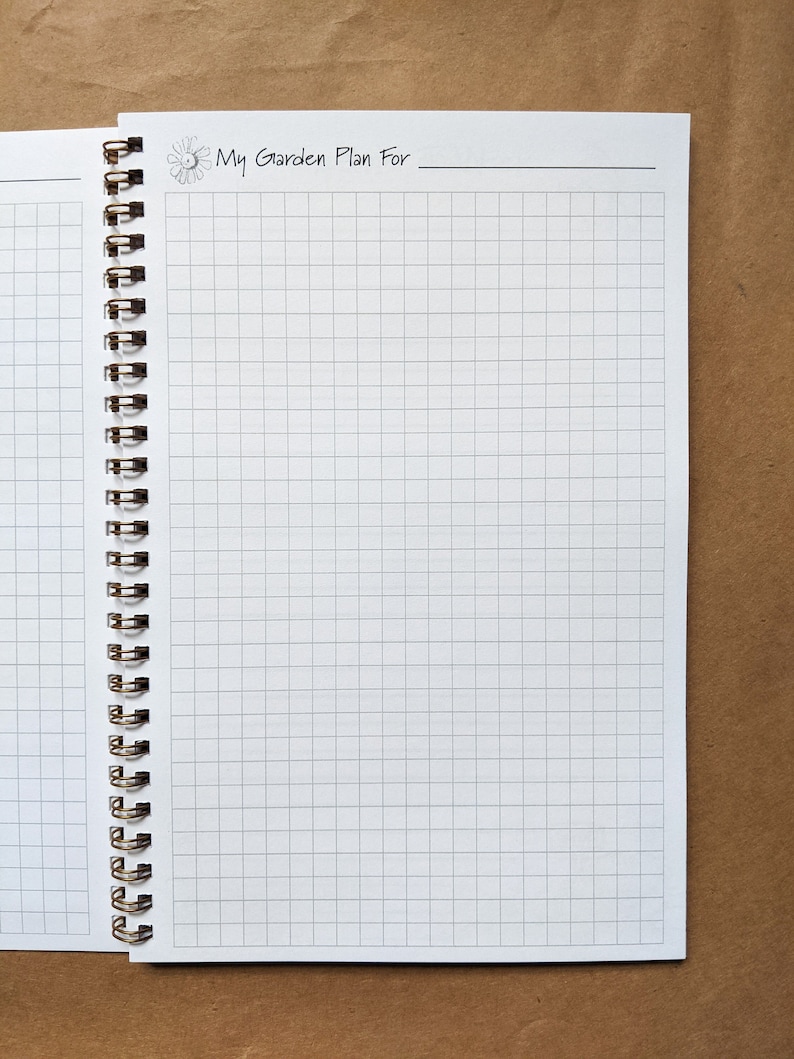 Pode incluir: Um caderno branco com um padr&atilde;o de grade e uma encaderna&ccedil;&atilde;o em espiral preta. A capa tem o texto "My Garden Plan For" com um pequeno s&iacute;mbolo de sol e lua.