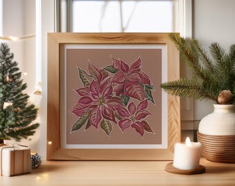 May include: A framed print of poinsettia flowers in shades of red and green. The artwork is displayed on a wooden surface, next to a small Christmas tree, a candle, and a vase with greenery. The overall theme is holiday decor.