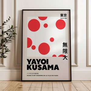 May include: A black and white poster with red circles on a white background. The poster features the text "Yayoi Kusama" in bold black letters, along with the text "Tokyo 1998" and "Musee d'Art Moderne de la Ville de Paris". The poster also includes the Japanese text "東京" and "無限大".