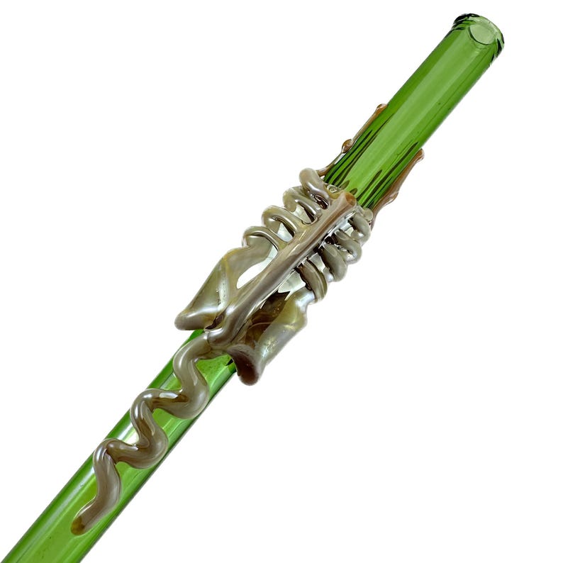 A green glass straw with a spiral design on it.
