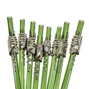 A group of green glass straws with spiral designs on them.