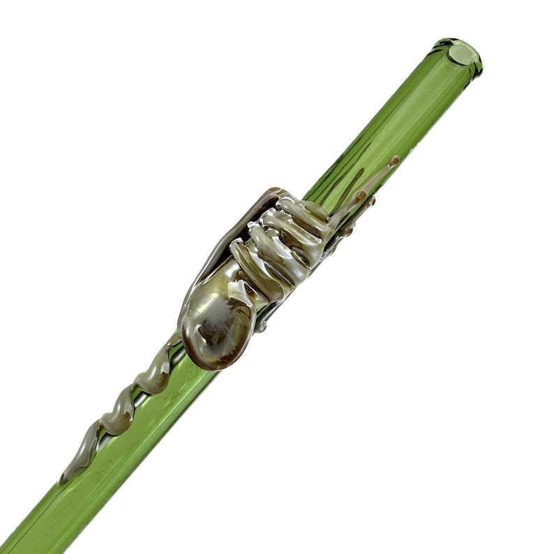 A green glass straw with a spiral design on it.