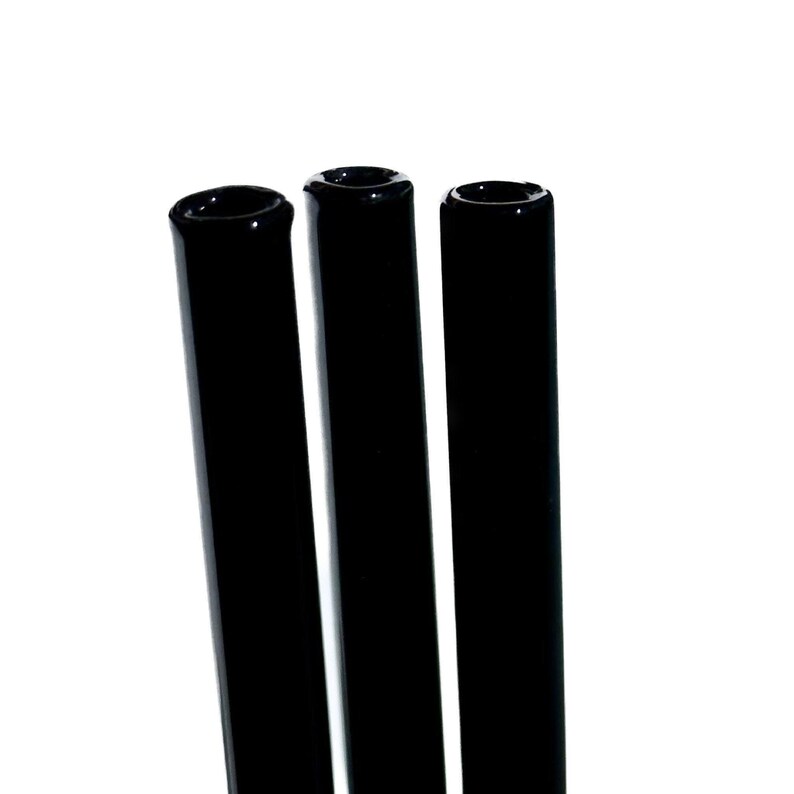 Three black cylindrical objects are arranged in a row against a white background.