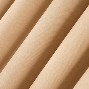 Puede incluir: Primer plano de tela beige doblada. La tela tiene una textura sutil y est&aacute; dispuesta en pliegues diagonales, creando una sensaci&oacute;n de profundidad. El color es un tono c&aacute;lido y neutro, adecuado para diversas aplicaciones.