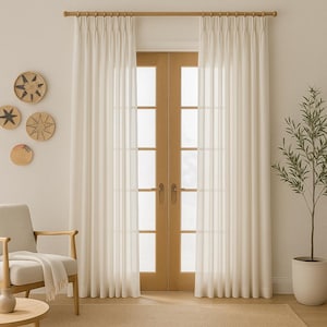 Peut inclure: Rideaux transparents crème suspendus à une tringle en bois, encadrant une porte en bois clair. Un petit arbre dans un pot blanc se trouve à droite. Décor mural tissé et une chaise avec une couverture sont visibles à gauche.