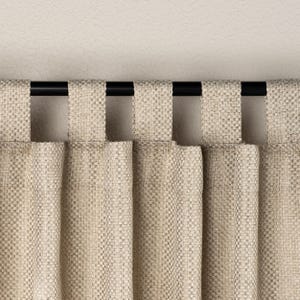 May include: Close-up of beige woven fabric curtains with a black rod. The curtains have a textured appearance and are hanging from the rod with fabric loops. The neutral colour and simple design suggest a minimalist style.