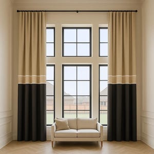 May include: Beige and black window curtains with a decorative border. The curtains are hung on a black rod and frame a large window with a view of a residential neighborhood. A beige sofa with a pillow sits below the window.