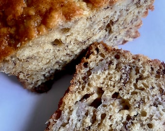 May include: Close-up of a banana bread loaf, sliced open to reveal the moist, dense crumb and visible banana chunks.