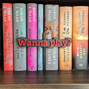 Op de afbeelding: Een verzameling boeken met kleurrijke ruggen, waaronder titels van Sarah J. Maas en Rebecca Yarros, gerangschikt op een houten plank. Een grijze, gestileerde tekst met de tekst "Wanna play?" is voor de boeken geplaatst.