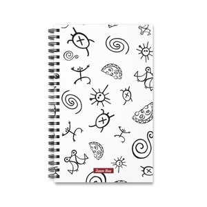 Pode incluir: Caderno de espiral branco com um padrão repetido de desenhos tribais pretos. Os desenhos incluem sóis, tartarugas, espirais e figuras de palitos. O caderno tem o texto "Jason Vive" no canto inferior direito.