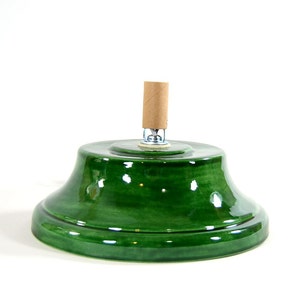 May include: Green ceramic Christmas tree stand with a brown cardboard center pole.