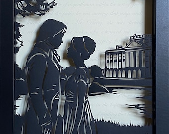 May include: A black and white paper cut-out art piece depicting a couple standing in front of a large building. The couple is silhouetted against a white background with text.