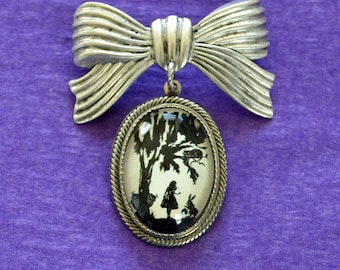 Alice in Wonderland Brooch - pendant on bow pin
