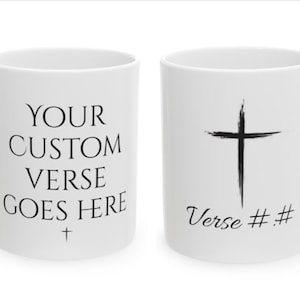 May include: Two white ceramic mugs. One mug has the text "YOUR CUSTOM VERSE GOES HERE" with a small cross at the bottom. The other mug has a black cross with a brushstroke effect and the text "Verse # #" at the bottom.