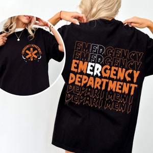 Two black t-shirts. One features an orange medical cross emblem with the text 'Emergency Department'. The other has the words 'Emergency Department' repeated in a stacked, distorted orange and white print on the back.