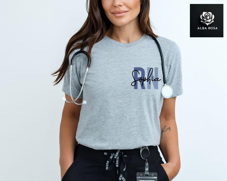 May include: A gray t-shirt with the text "RN Sophia" printed on the front. The shirt is being worn by a person with a stethoscope around their neck.