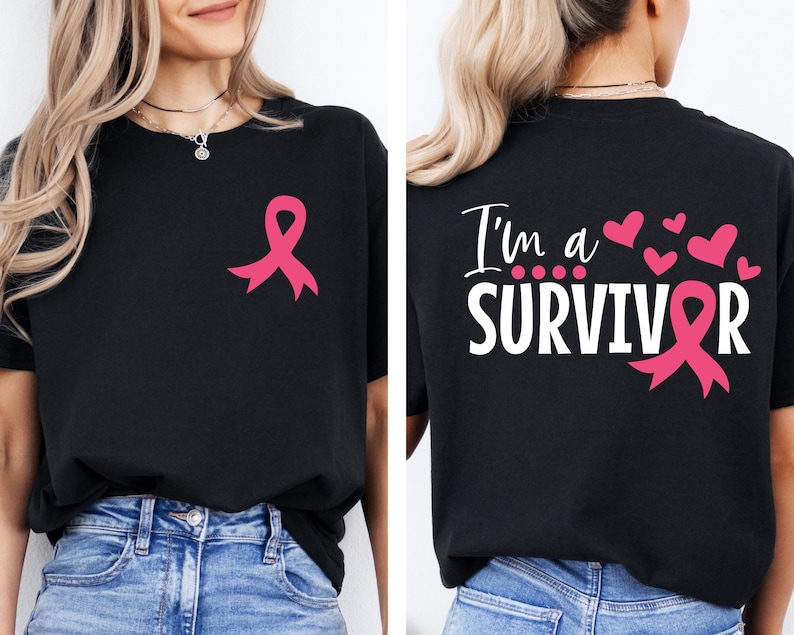 Op de afbeelding: Zwart T-shirt met een roze lint op de voorkant en de tekst "I'm a SURVIVOR" met een roze lint op de achterkant. Het shirt is een symbool voor bewustwording van borstkanker.