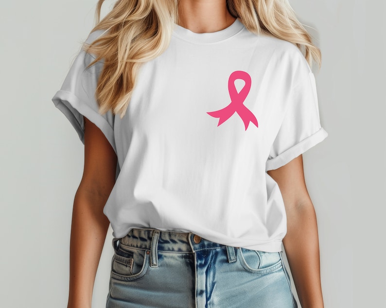 Op de afbeelding: Een wit T-shirt met een roze lint aan de linkerkant van de borst. Het lint is een symbool voor bewustwording van borstkanker.