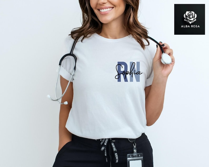 May include: White t-shirt with the text "RN Sophia" in blue and black lettering. A stethoscope is draped around the neck of the person wearing the shirt.