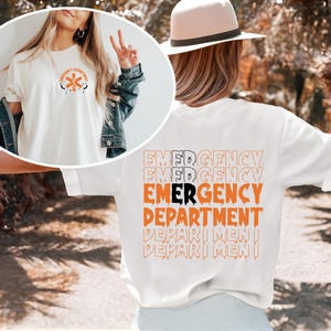 May include: White t-shirt with an orange and black "Emergency Department" graphic on the back. The front of the shirt has a smaller orange and black graphic of a medical star.