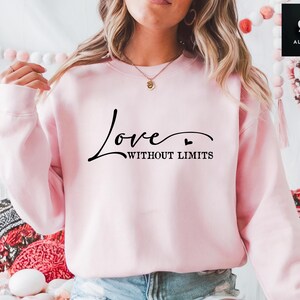May include: Pink sweatshirt with the text "Love Without Limits" in black script.