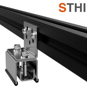 Puede incluir: Un riel de metal negro con un soporte de metal plateado fijado a él. El soporte tiene varios agujeros y está asegurado con tornillos. El riel está etiquetado como "STHIEL".